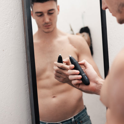 man holding trimmer in mirror
